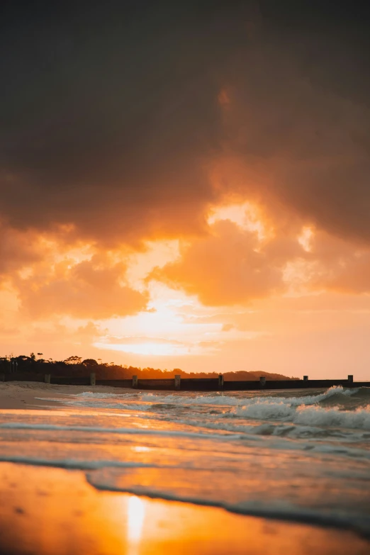 the sun sets in front of a large body of water