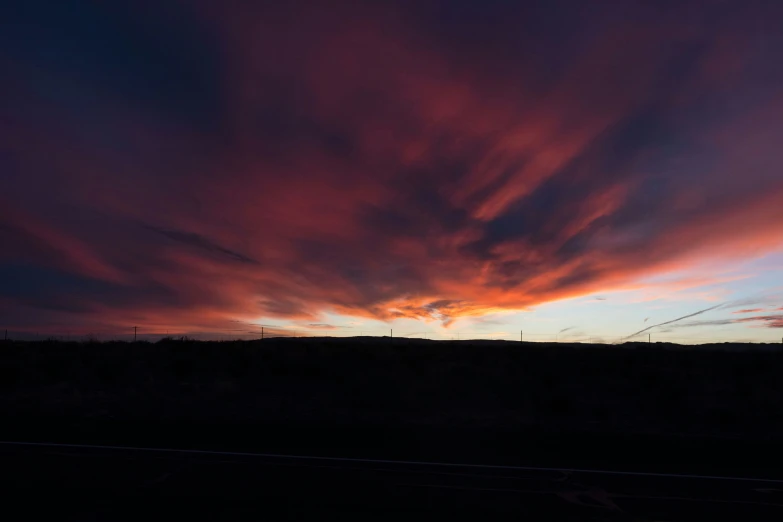 a sunset with clouds in the sky and no one in the distance