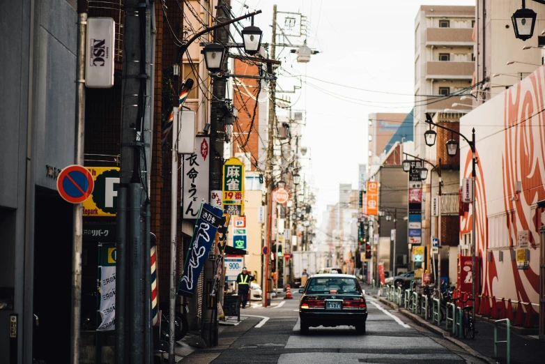 a car is driving through an asian narrow street