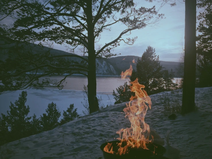 a fire is lit up on the top of the snowy hill