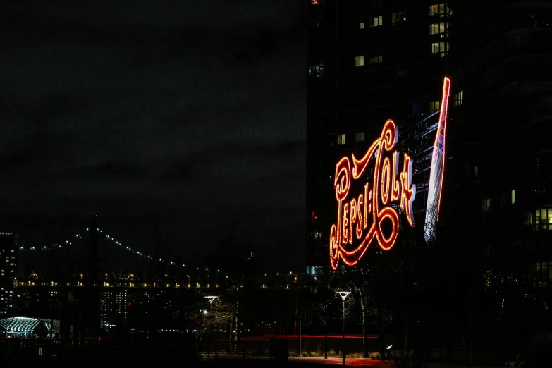 an illuminated sign is seen over a large city