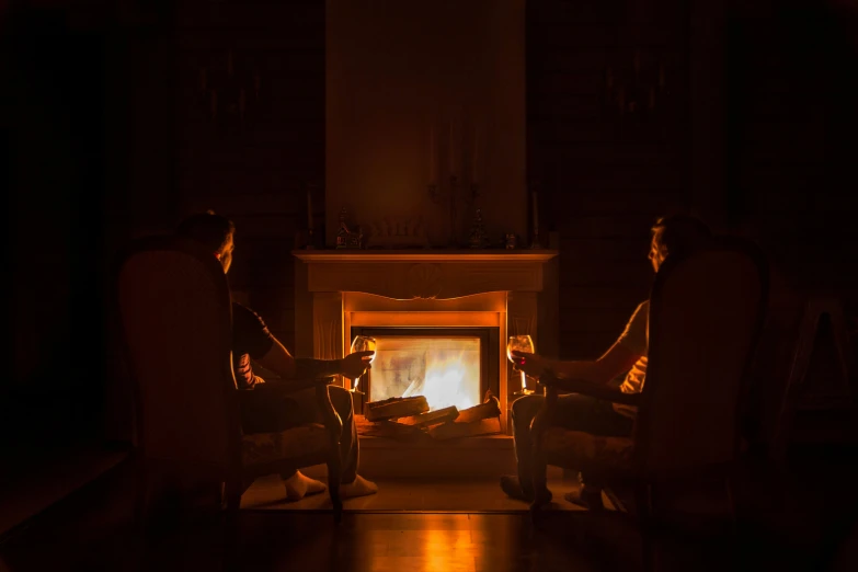 two people sitting in chairs watching soing on the television