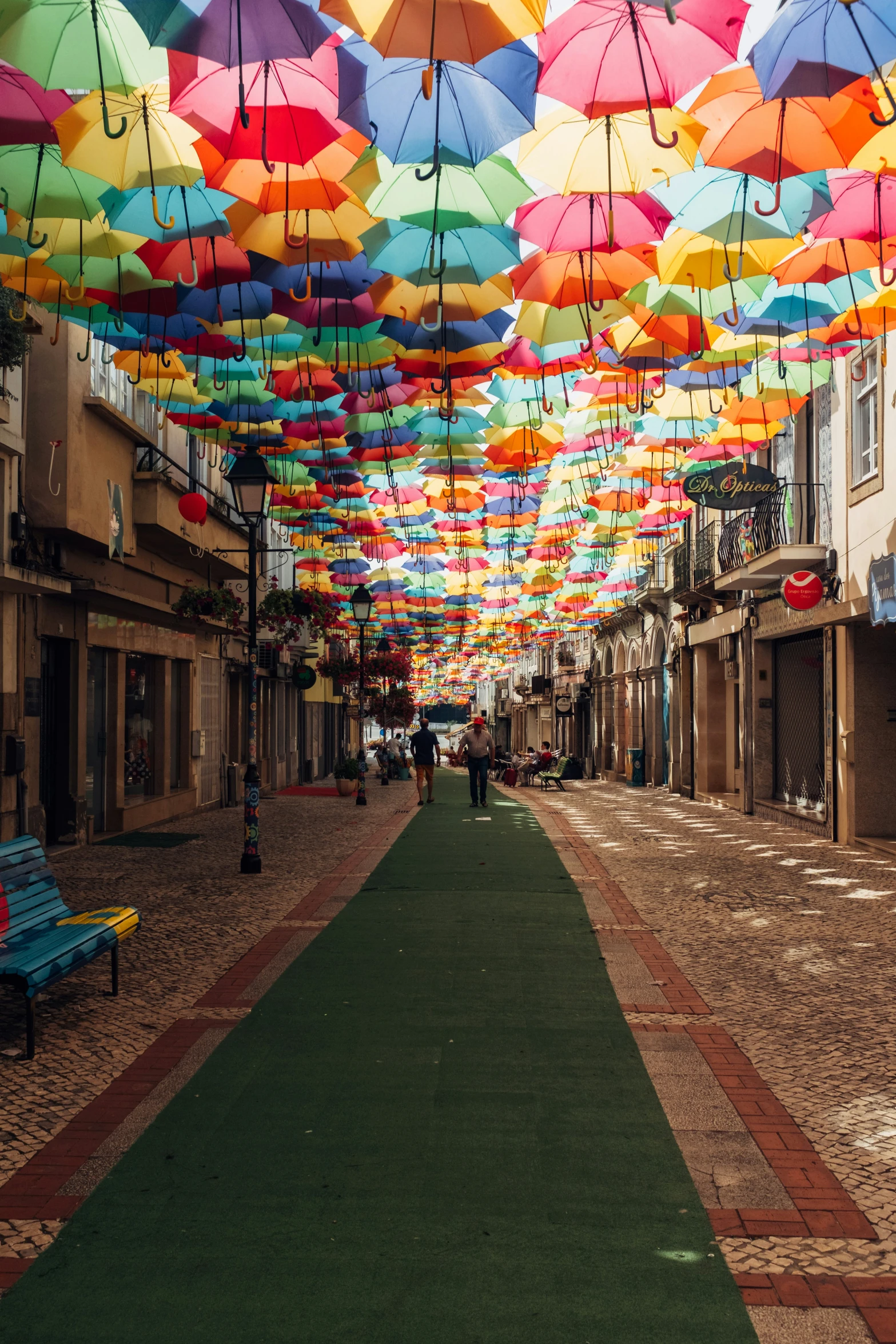 a hallway lined with multicolored umbrellas of various shapes