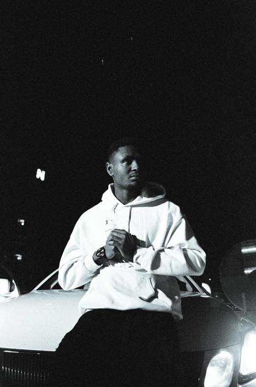a man sitting on top of a car at night
