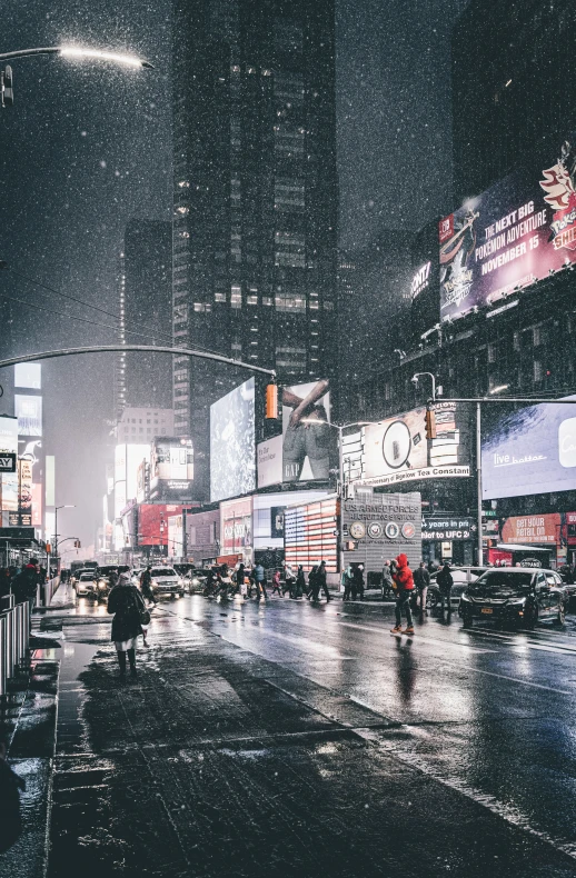 people walking across a rainy city street at night