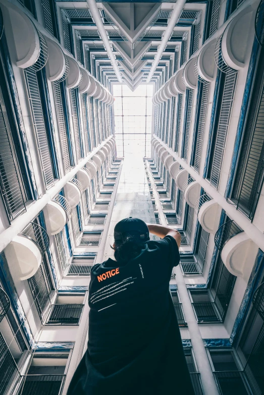 a man standing in a hallway between rows of servers