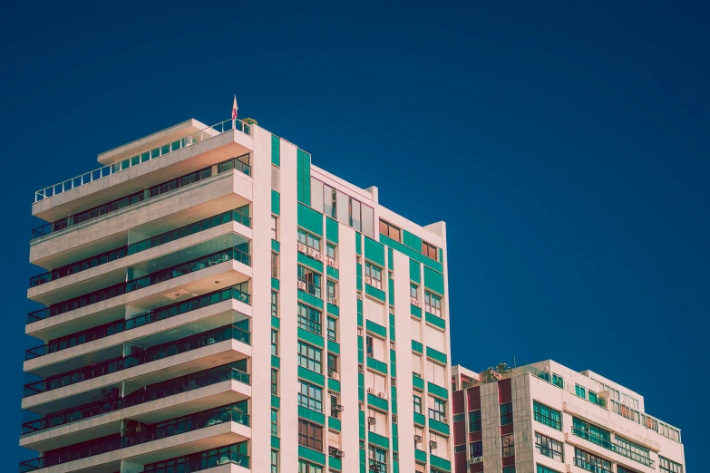 tall building with green windows in the day