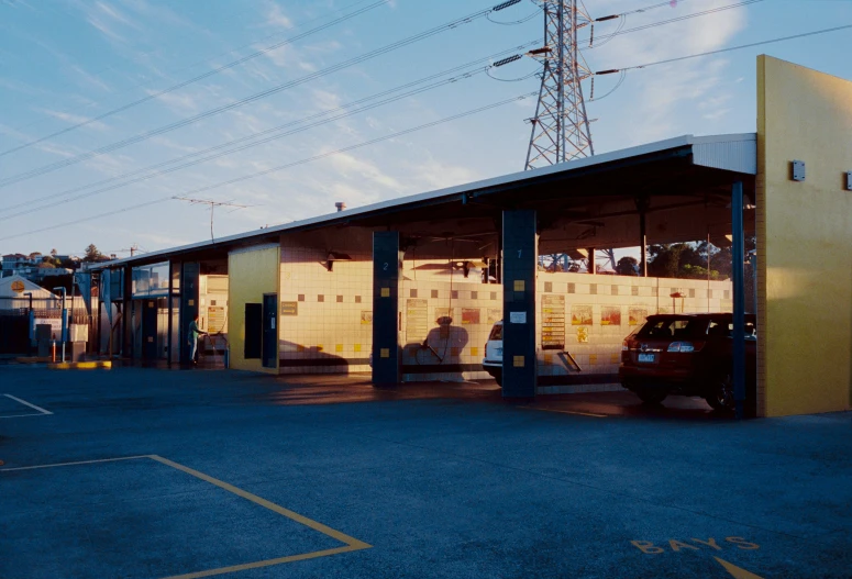 a car is parked in front of a small structure with an electrical sub