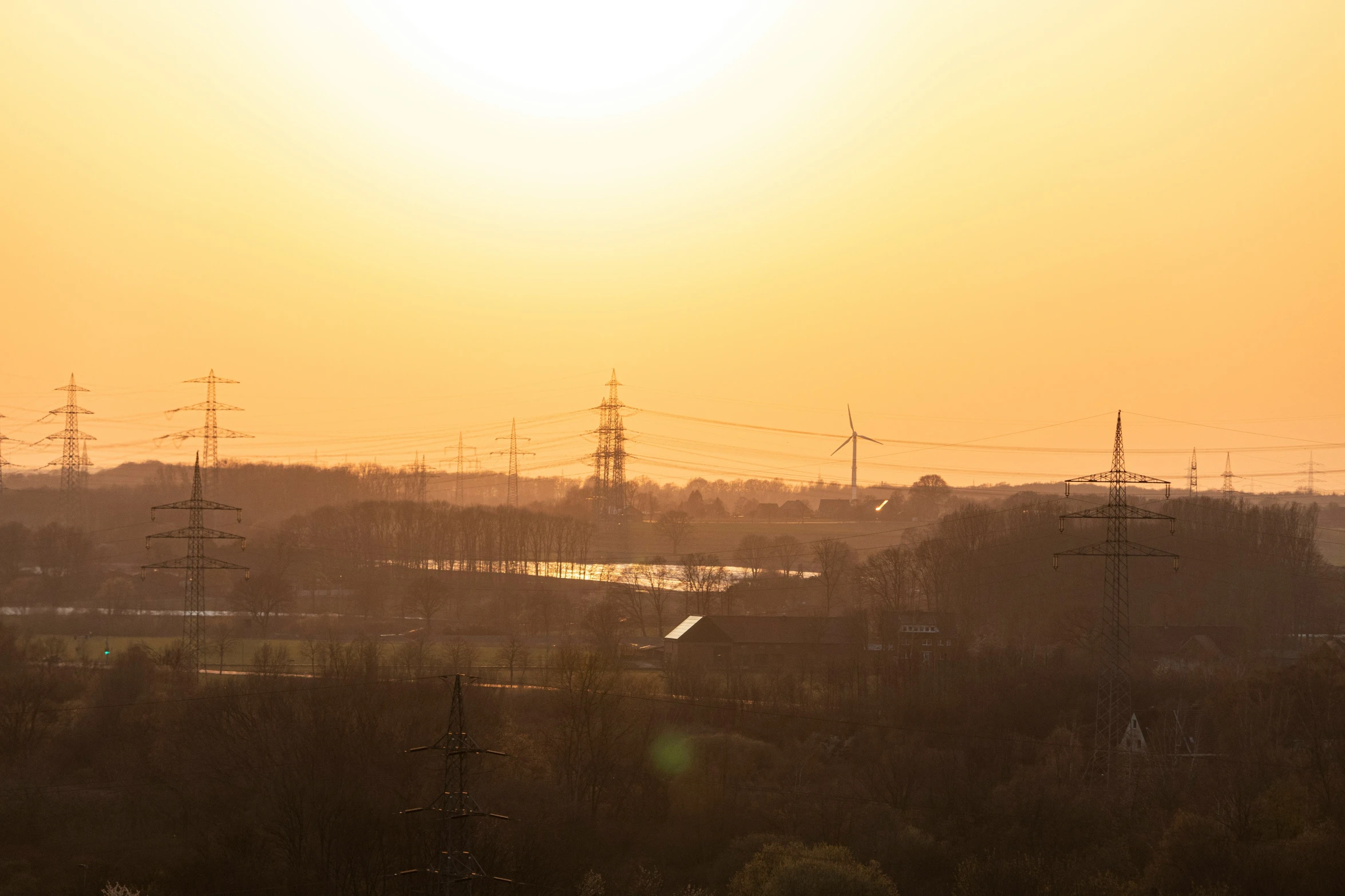 the sun is setting over the power lines