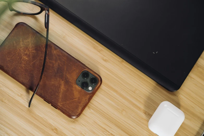 a pair of glasses and an iphone 11 pro case on a table