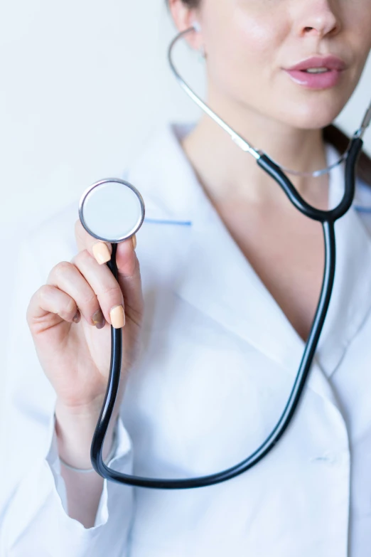 a female doctor checking her  pressure with a stethoscope