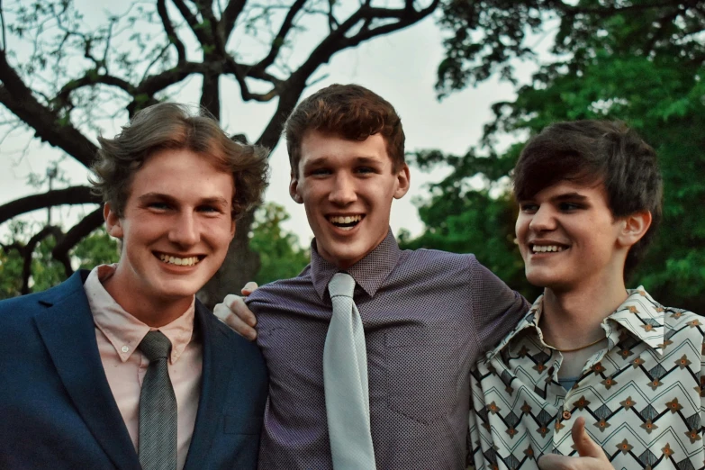 a trio of young men, one wearing a tie and two with jacket jackets