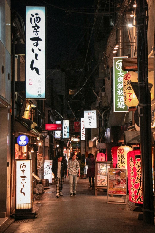 a city street with asian writing hanging above it