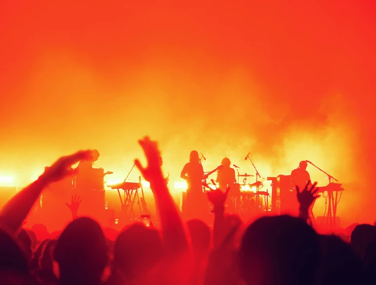 a band performing at a concert in the middle of a huge crowd