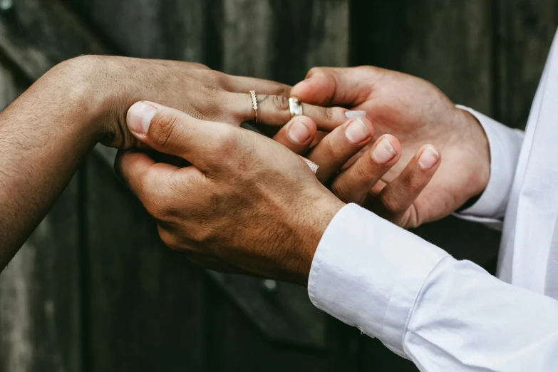 two people are standing close together and one is holding another hand