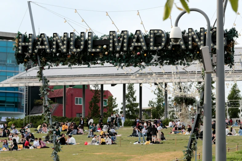 a group of people sitting under the name sign of the university