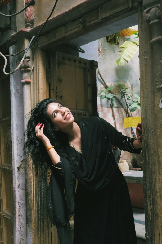 a woman with long black hair talking on a cellphone