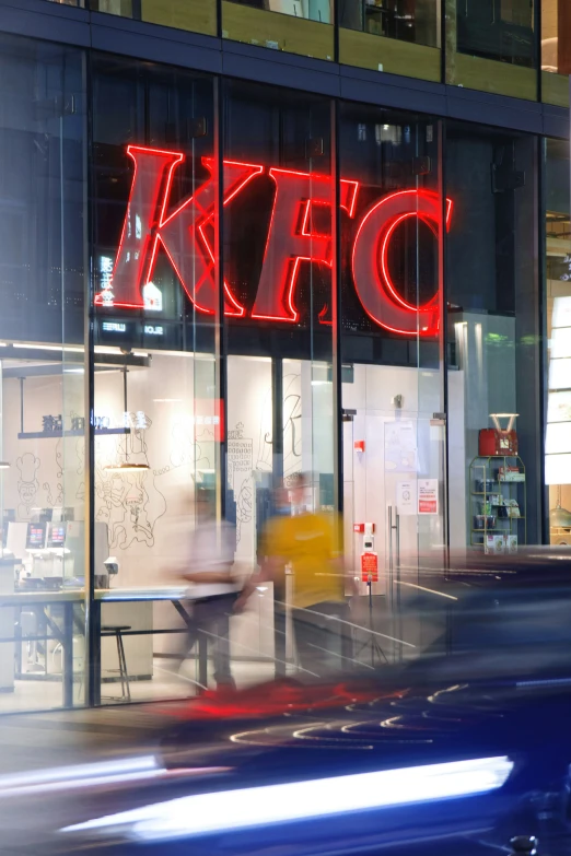 a large neon sign on a building in front of a cafe