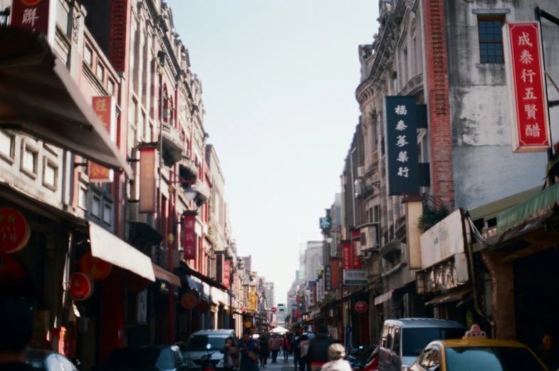 this looks like an asian city street with lots of cars and people