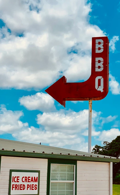 the red sign is pointing to the ice cream parlor