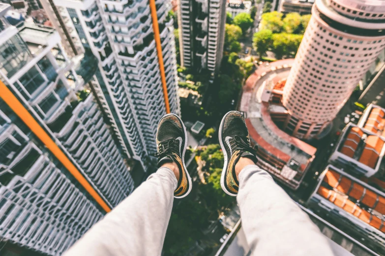 person standing high up with their feet up above the city