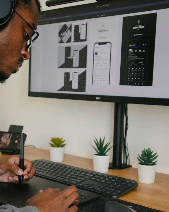 man looking at his phone while using the computer