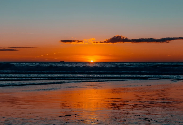 the sun is rising over a body of water