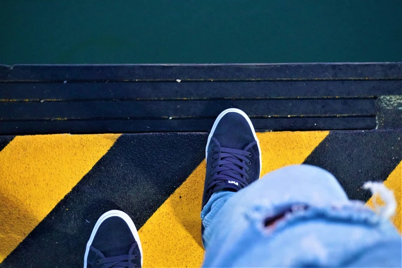 the person is wearing black and white shoes on the road