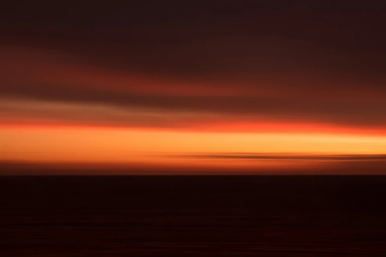 a person surfing on waves with the sun just above them