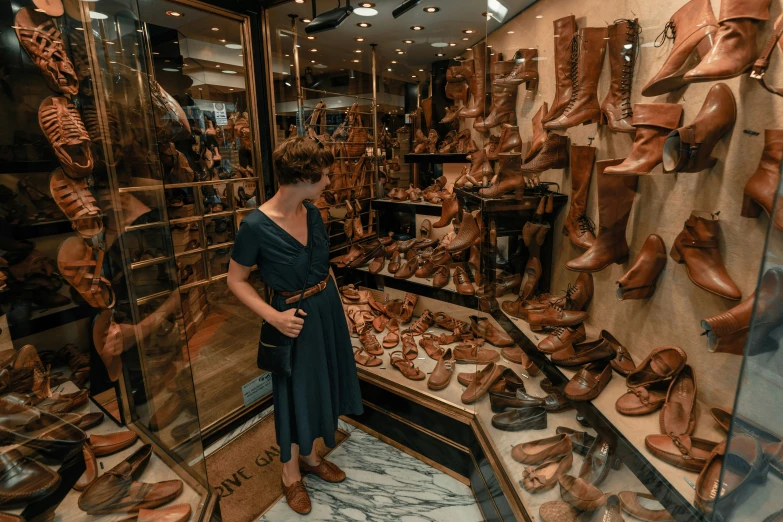 a woman stands in front of many types of shoes