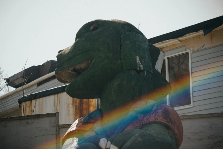 a statue of a dinosaur is painted with a rainbow