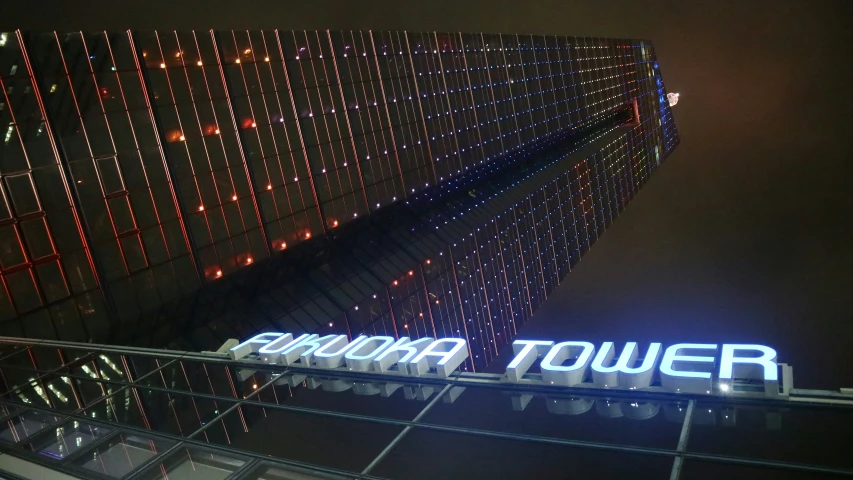 a building is decorated in lights with a neon sign on the side