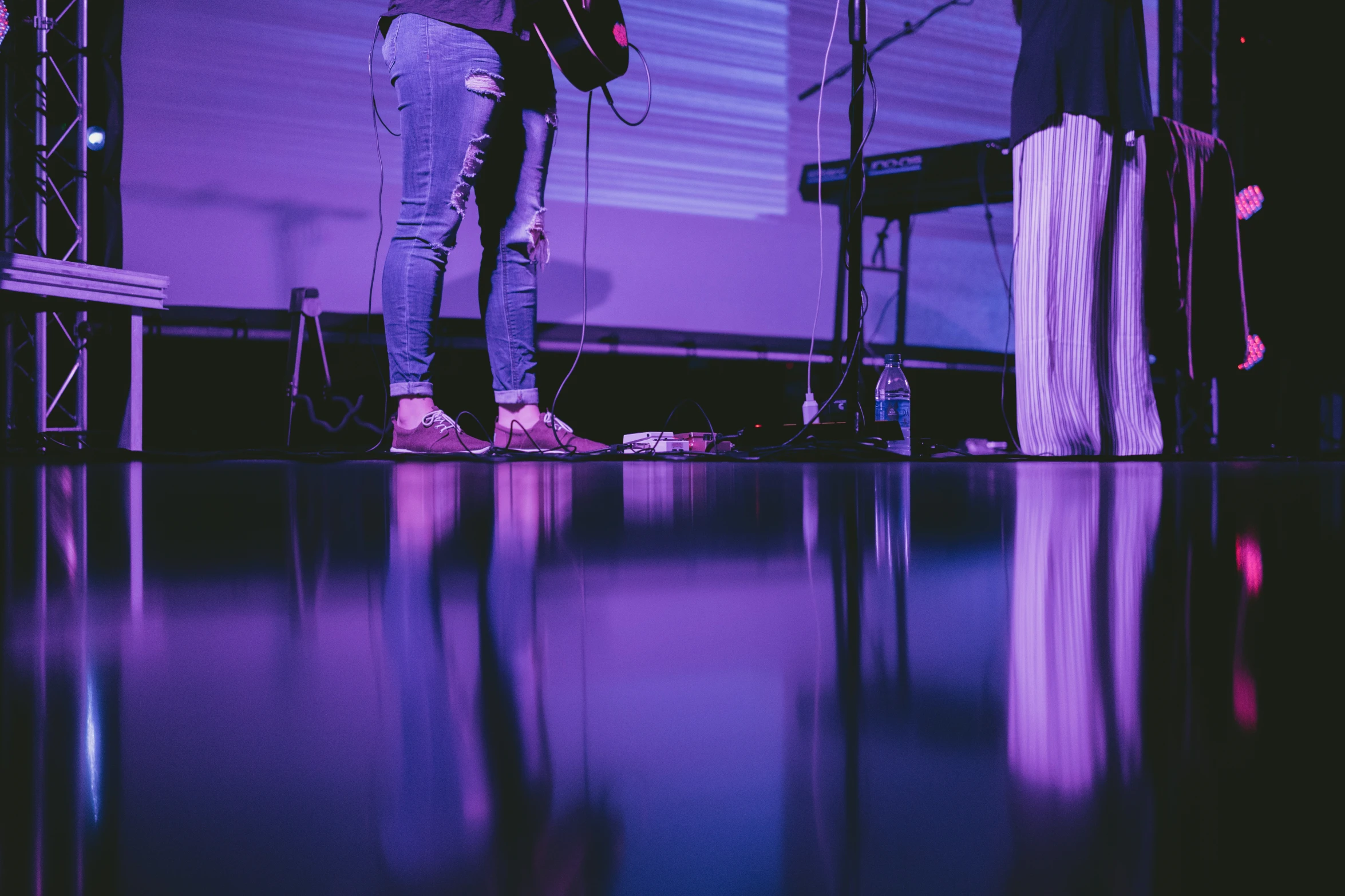 a woman is playing on the guitar on stage