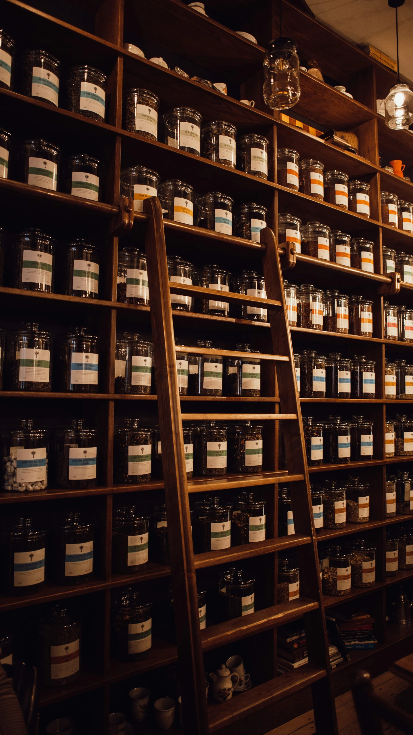 a ladder leaning against the side of a wall filled with jars