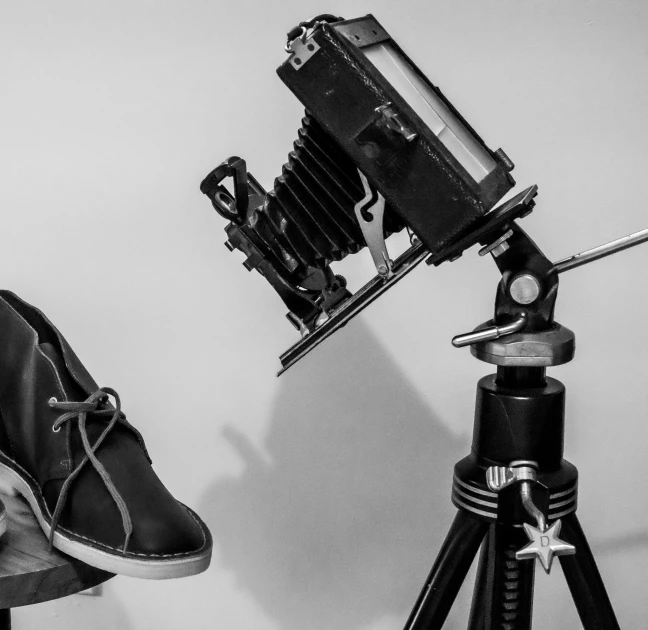 the camera and shoes are sitting on top of the tripod