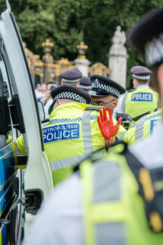 police in uniform stand near a car on a street