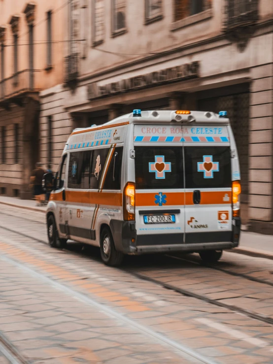 a ambulance driving on the street near some buildings