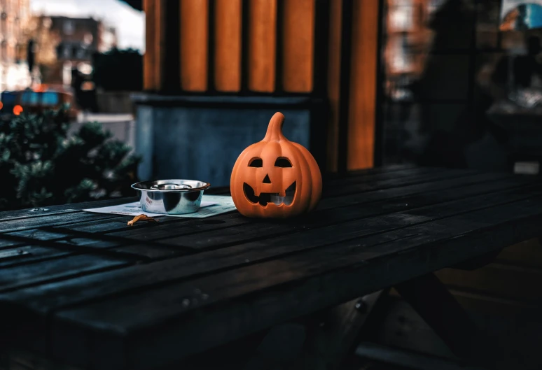 a wooden table topped with a pumpkin face