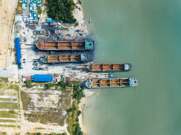 four wooden boats parked at a dock on the sand