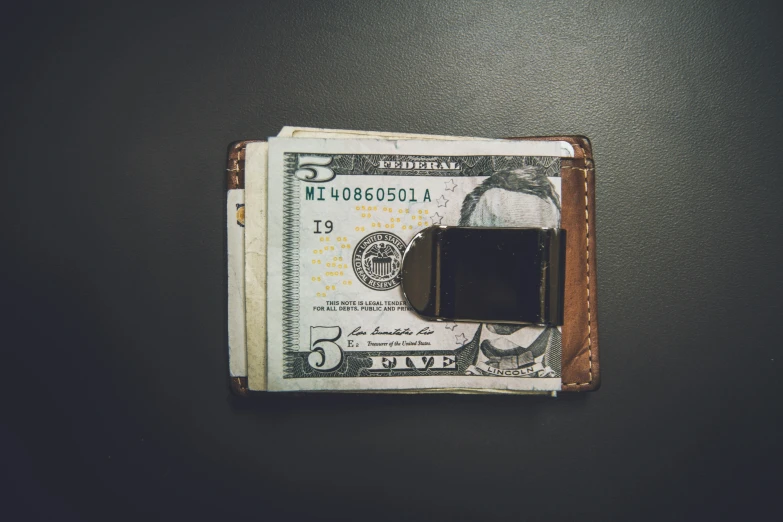 an opened wallet on top of some money