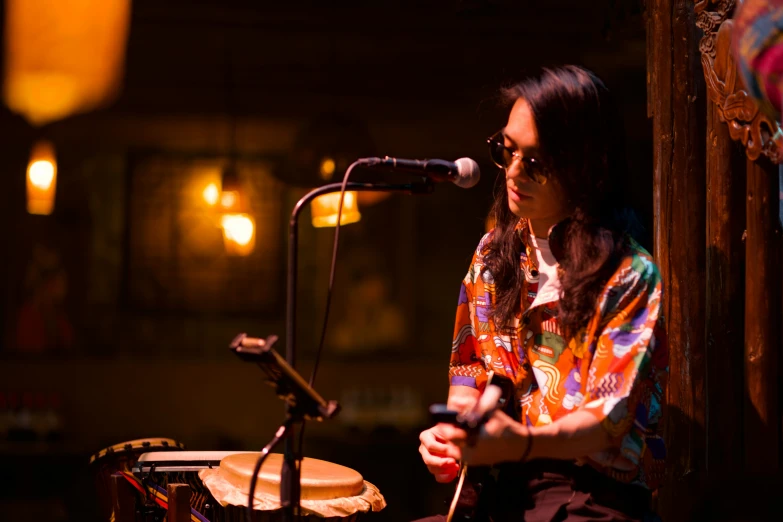 the young woman is playing the drums in front of the microphone