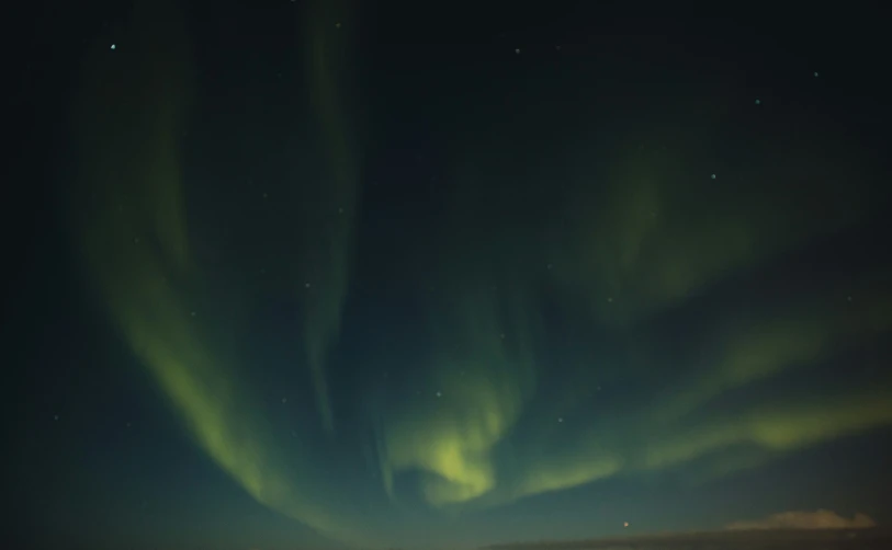 a person sitting down watching the aurora and other lights