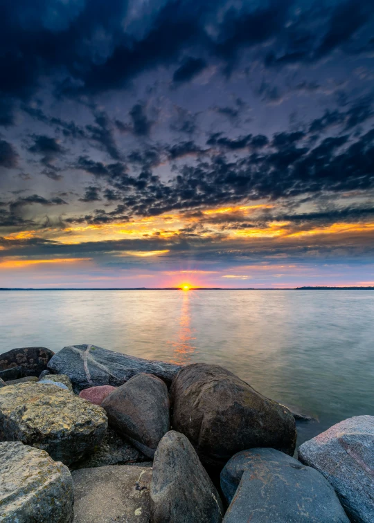 the sky over water has red and blue clouds