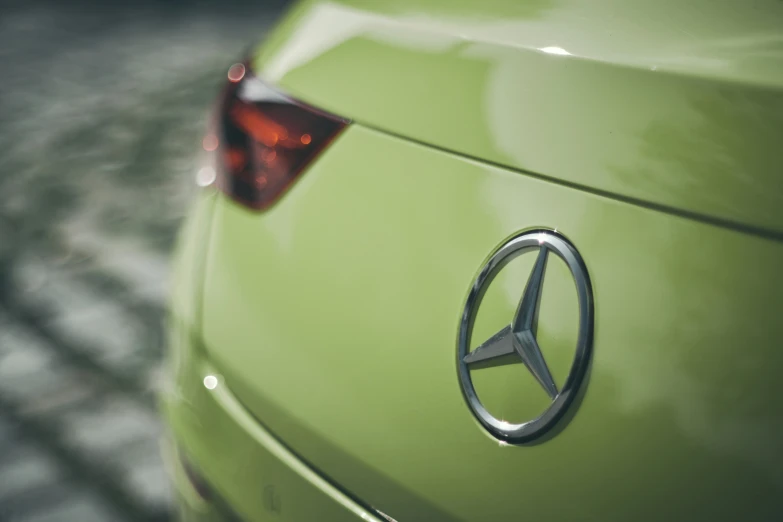 a green mercedes logo on the back end of a car