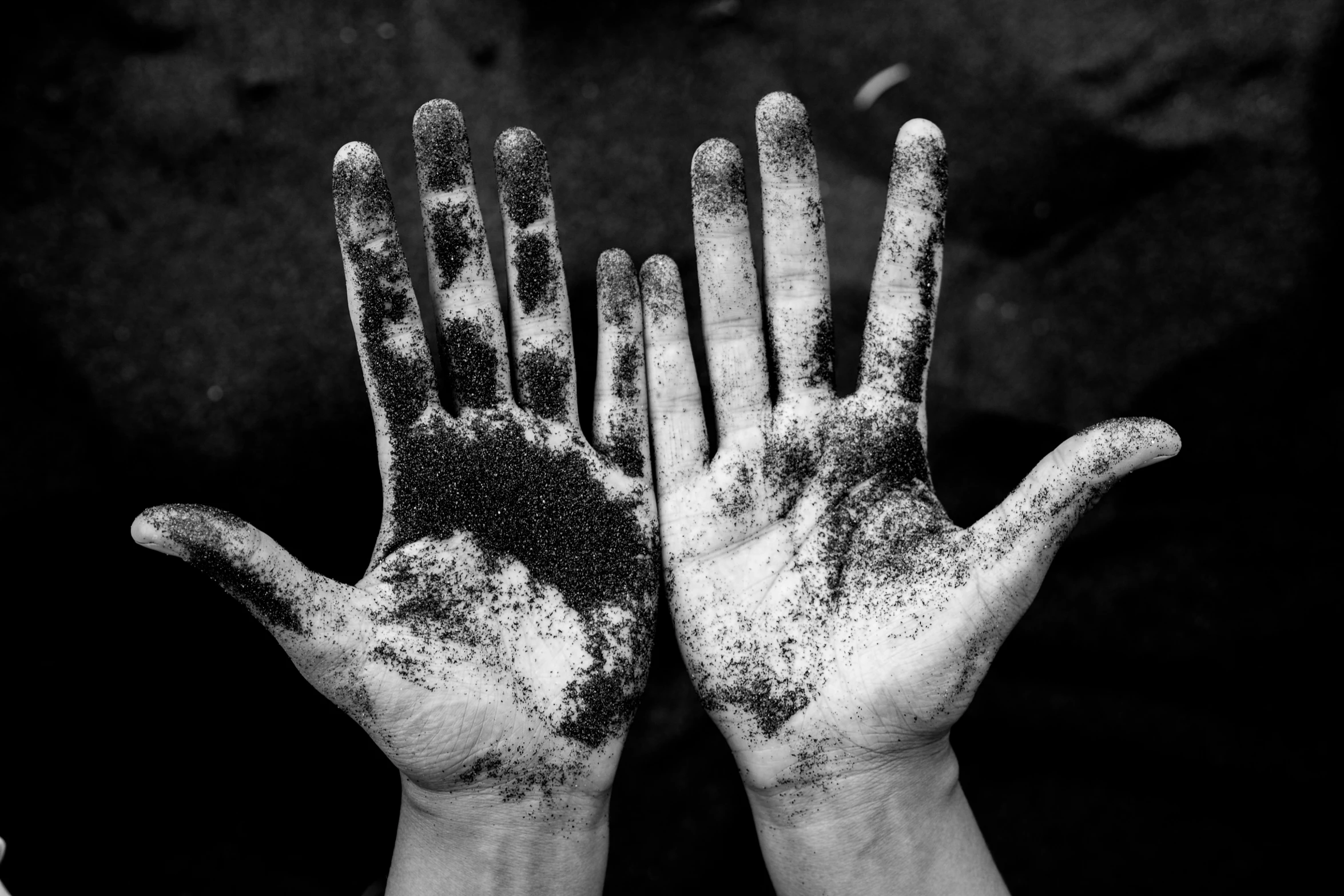 a person holding up their hands covered with dirt