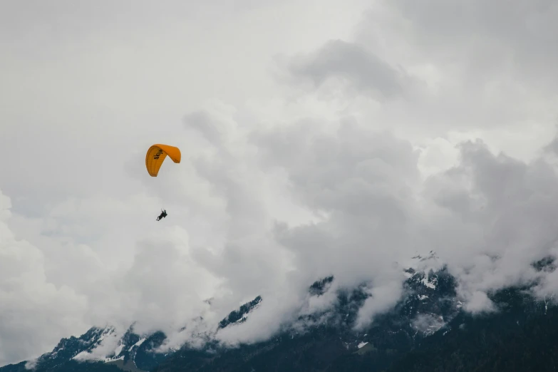 a mountain with a parachute being flown by two people