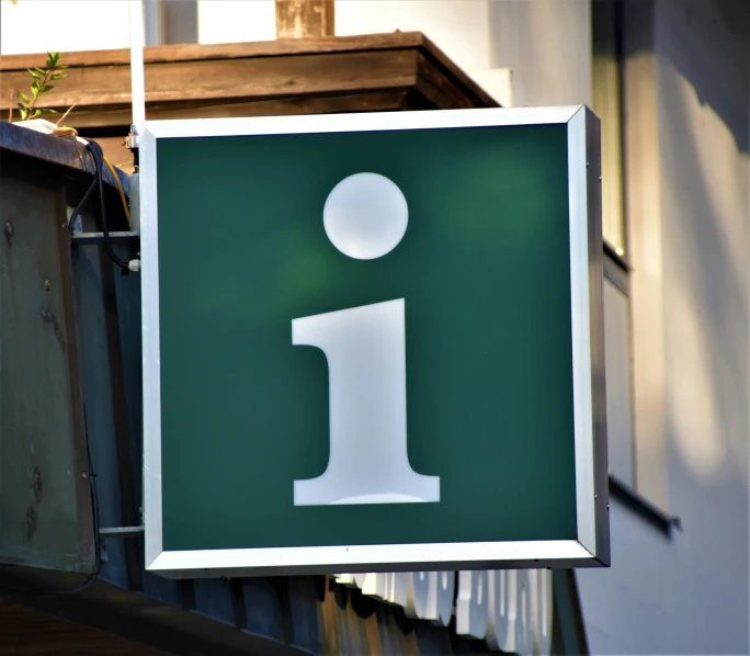 this is an image of a green sign in front of a building
