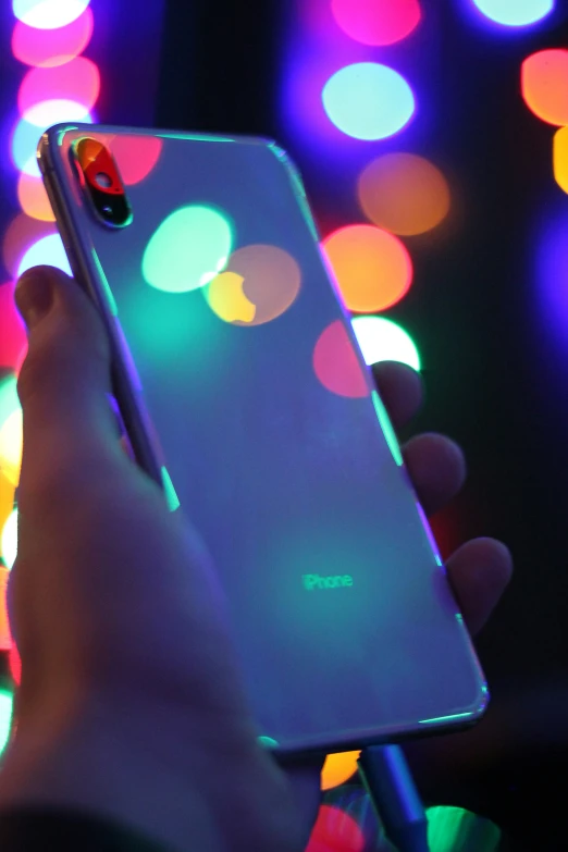a person holding an iphone in their hands at night