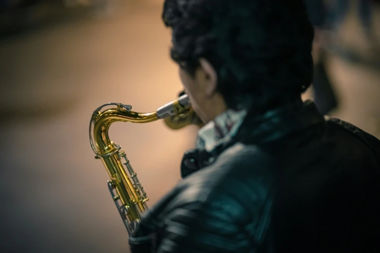 a person standing with his face close to his mouth holding a saxophone