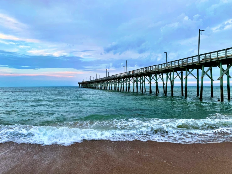 a large pier on the ocean with waves coming towards it